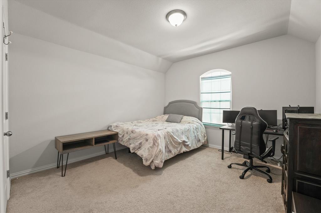 3217 Flowering Peach Dr. Heath, TX 75126 - Photo 17 of 30 a bedroom with a bed a desk and chair