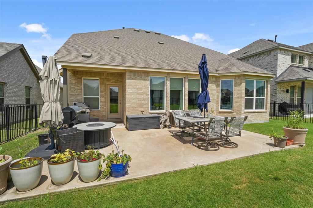3217 Flowering Peach Dr. Heath, TX 75126 - Photo 26 of 30 a view of a patio with table and chairs potted plants and floor to ceiling window