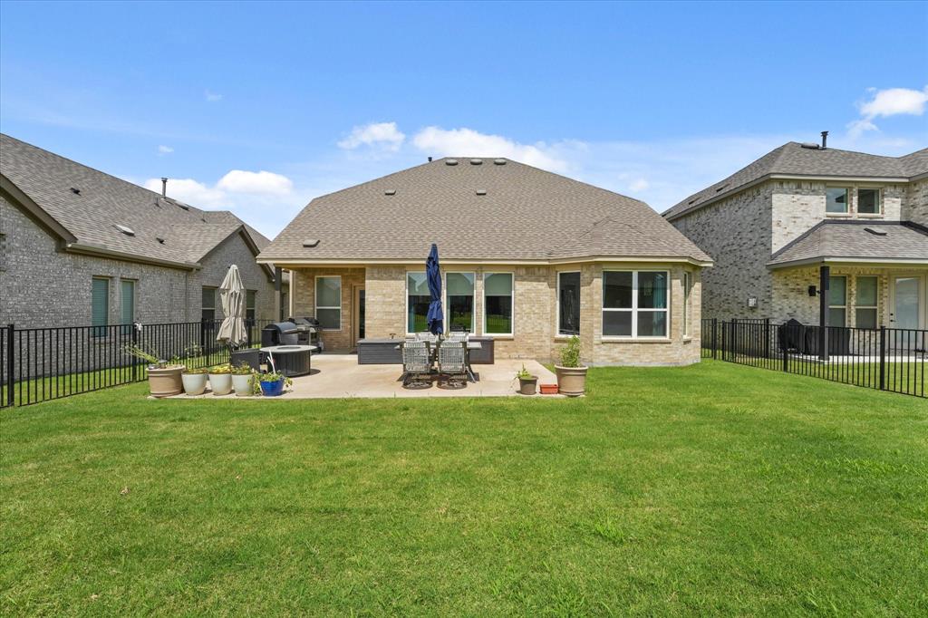 3217 Flowering Peach Dr. Heath, TX 75126 - Photo 27 of 30 a front view of a house with backyard sitting area and garden