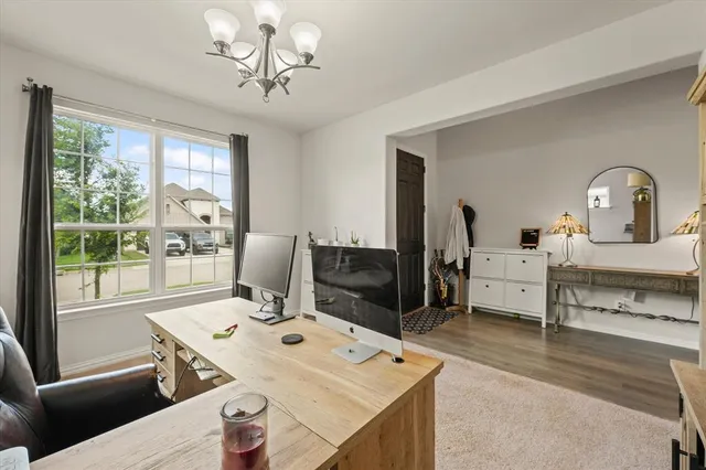 a view of a workspace with furniture and a window