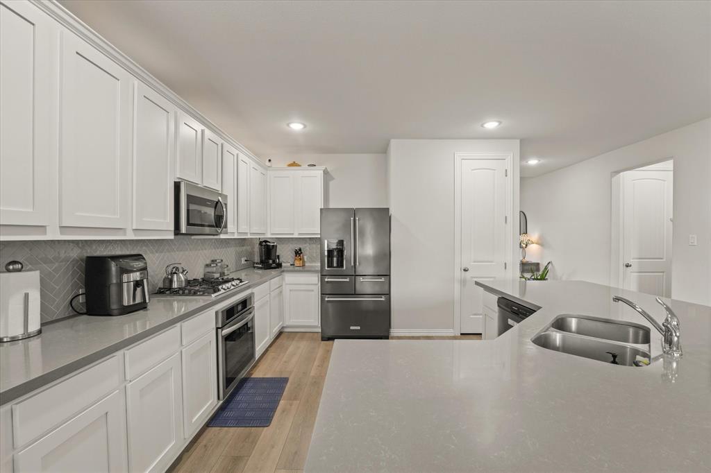 3217 Flowering Peach Dr. Heath, TX 75126 - Photo 8 of 30 a kitchen with refrigerator a sink and cabinets