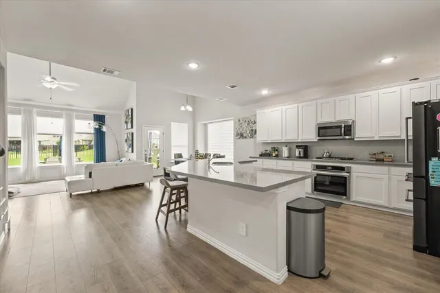 a kitchen with a sink a counter top space stainless steel appliances and cabinets