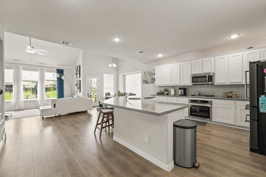 3217 Flowering Peach Dr. Heath, TX 75126 - Photo 9 of 30 a kitchen with a sink a counter top space stainless steel appliances and cabinets