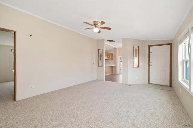 a view of a livingroom with a ceiling fan and window