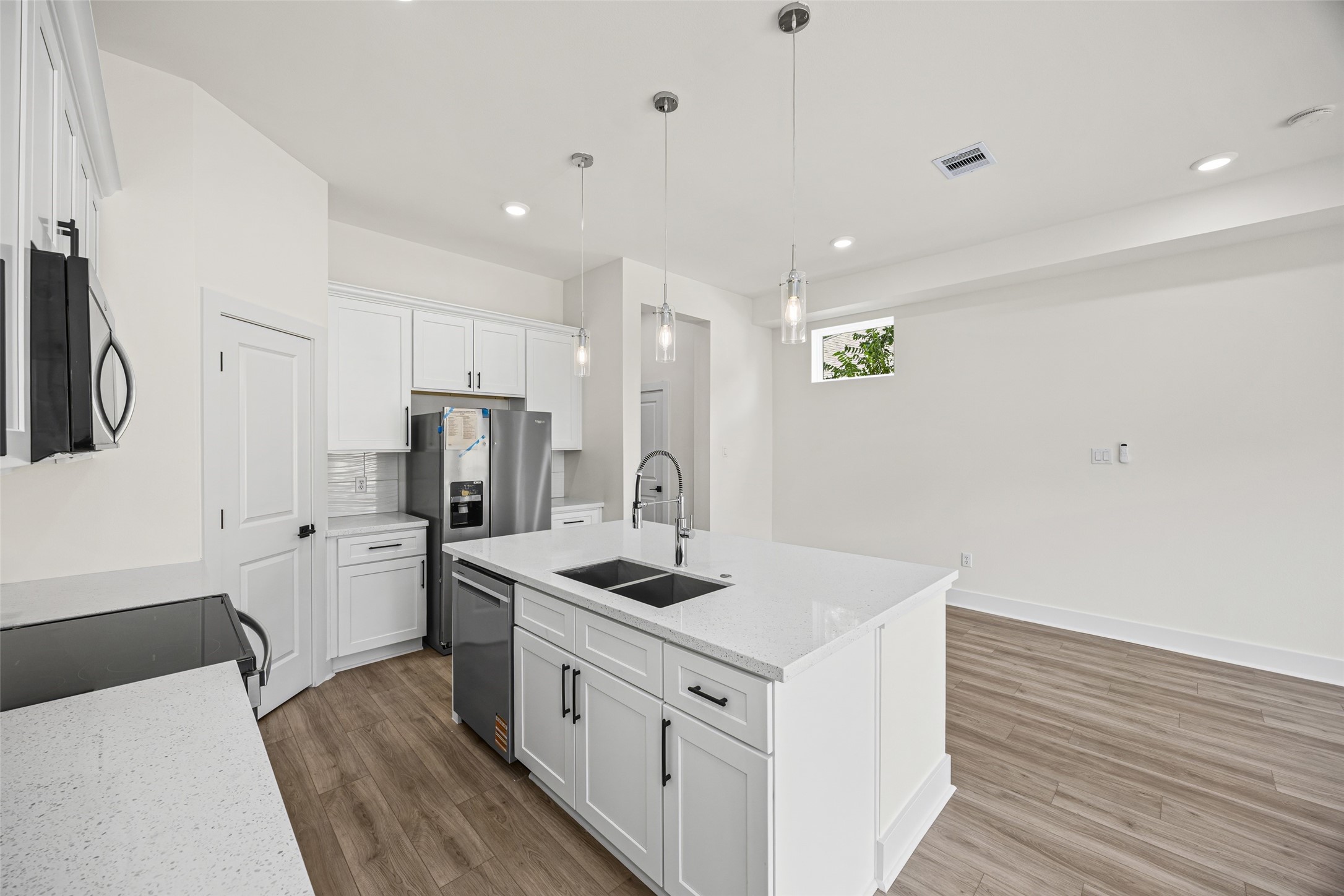 443 Hahlo Street Houston, TX 77020 - Photo 11 of 27 a kitchen with refrigerator cabinets and wooden floor