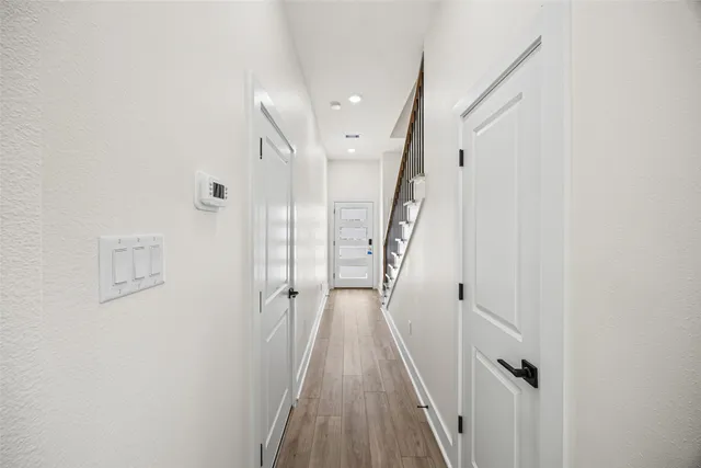 a view of a hallway with wooden floor and staircase