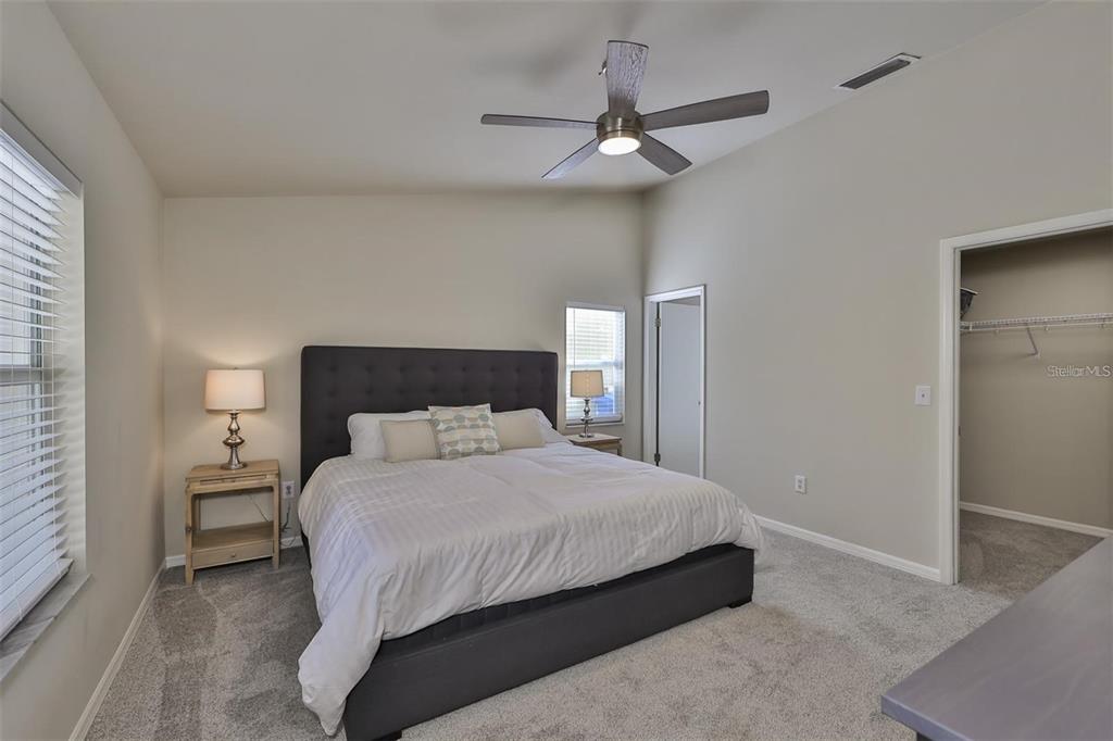 128 Lookout Drive Apollo Beach, FL 33572 - Photo 18 of 36 a bedroom with a bed and a chandelier