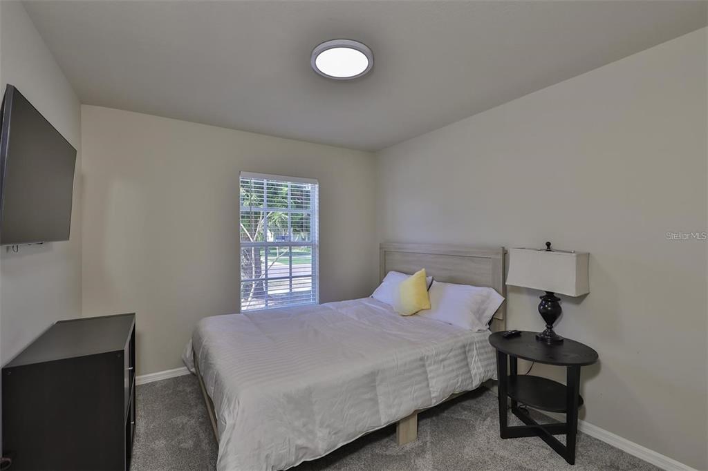 128 Lookout Drive Apollo Beach, FL 33572 - Photo 23 of 36 a bedroom with a bed and a flat tv screen on a dresser