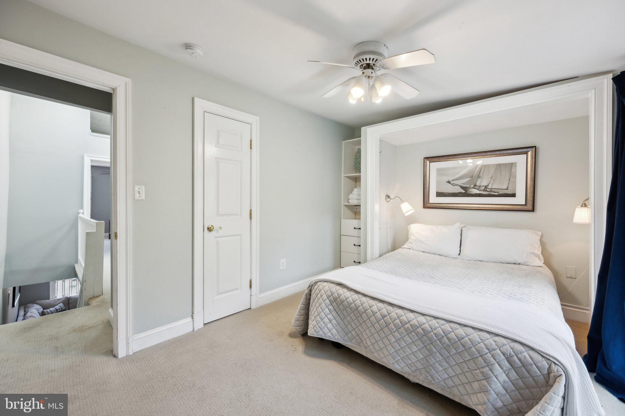 24 Fleet Street Annapolis, MD 21401 - Photo 14 of 32 a bedroom with a large bed and a chandelier