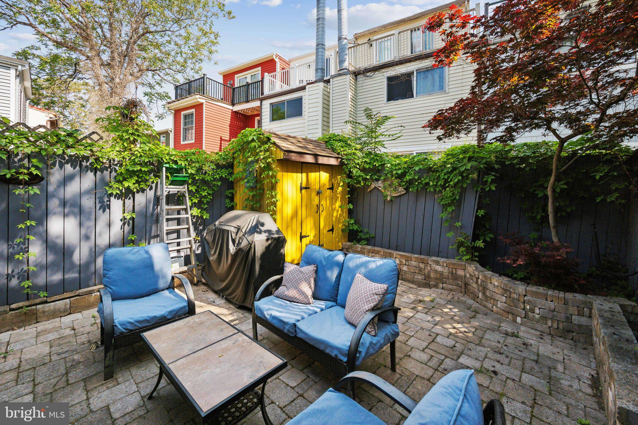24 Fleet Street Annapolis, MD 21401 - Photo 24 of 32 a view of a patio with couches and a table and chairs with wooden fence and plants