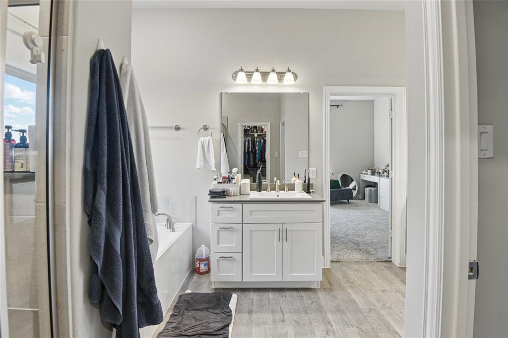 1164 Red Hawk Lane Forney, TX 75126 - Photo 14 of 27 a en suite bathroom with a sink a mirror and a bathtub