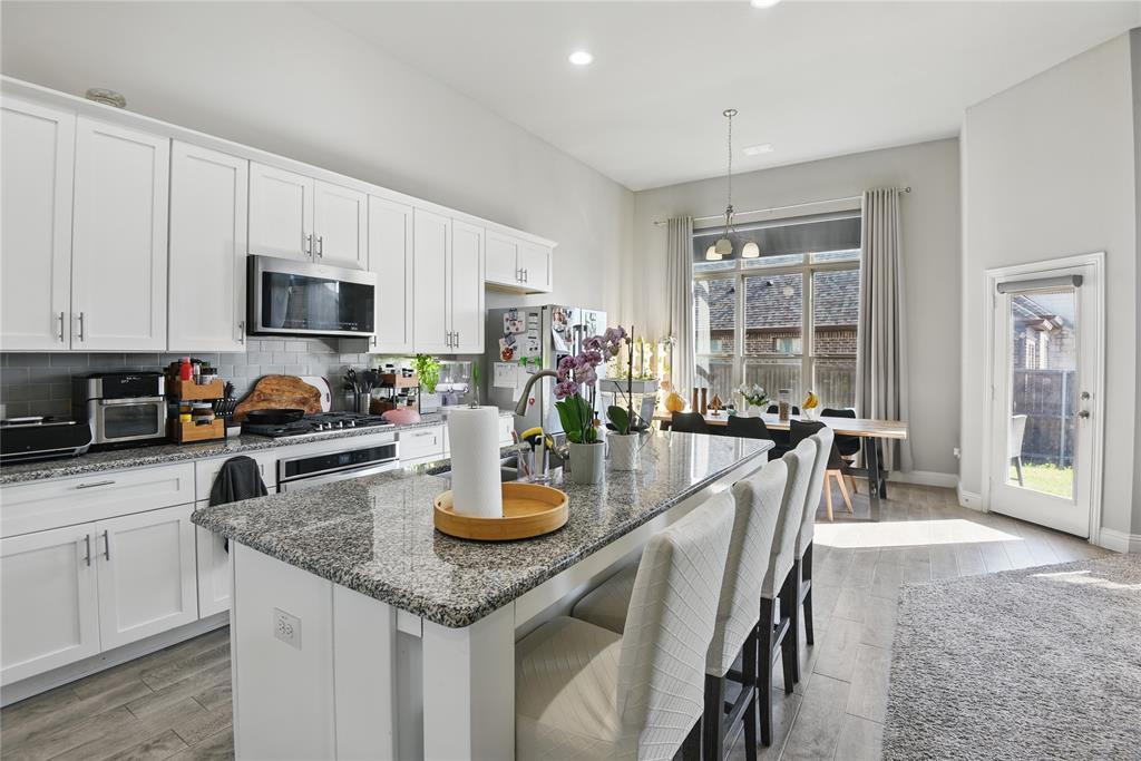 1164 Red Hawk Lane Forney, TX 75126 - Photo 5 of 27 a kitchen with a table chairs stove and cabinets