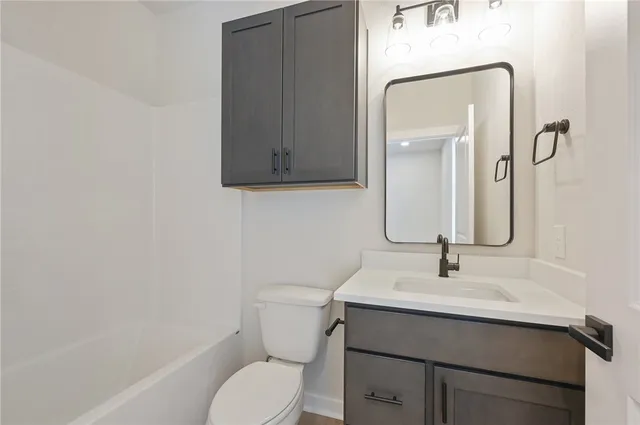 an empty room with closet and a ceiling fan