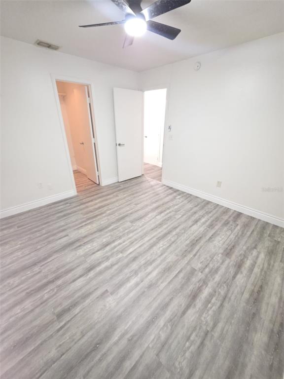 2358 Water View Loop Kissimmee, FL 34743 - Photo 26 of 26 an empty room with wooden floor and a ceiling fan