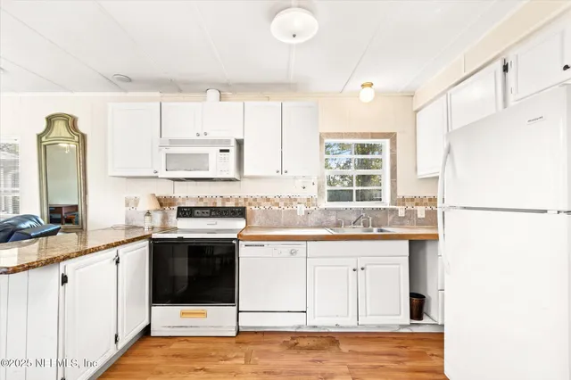 a kitchen with granite countertop a sink stove and refrigerator