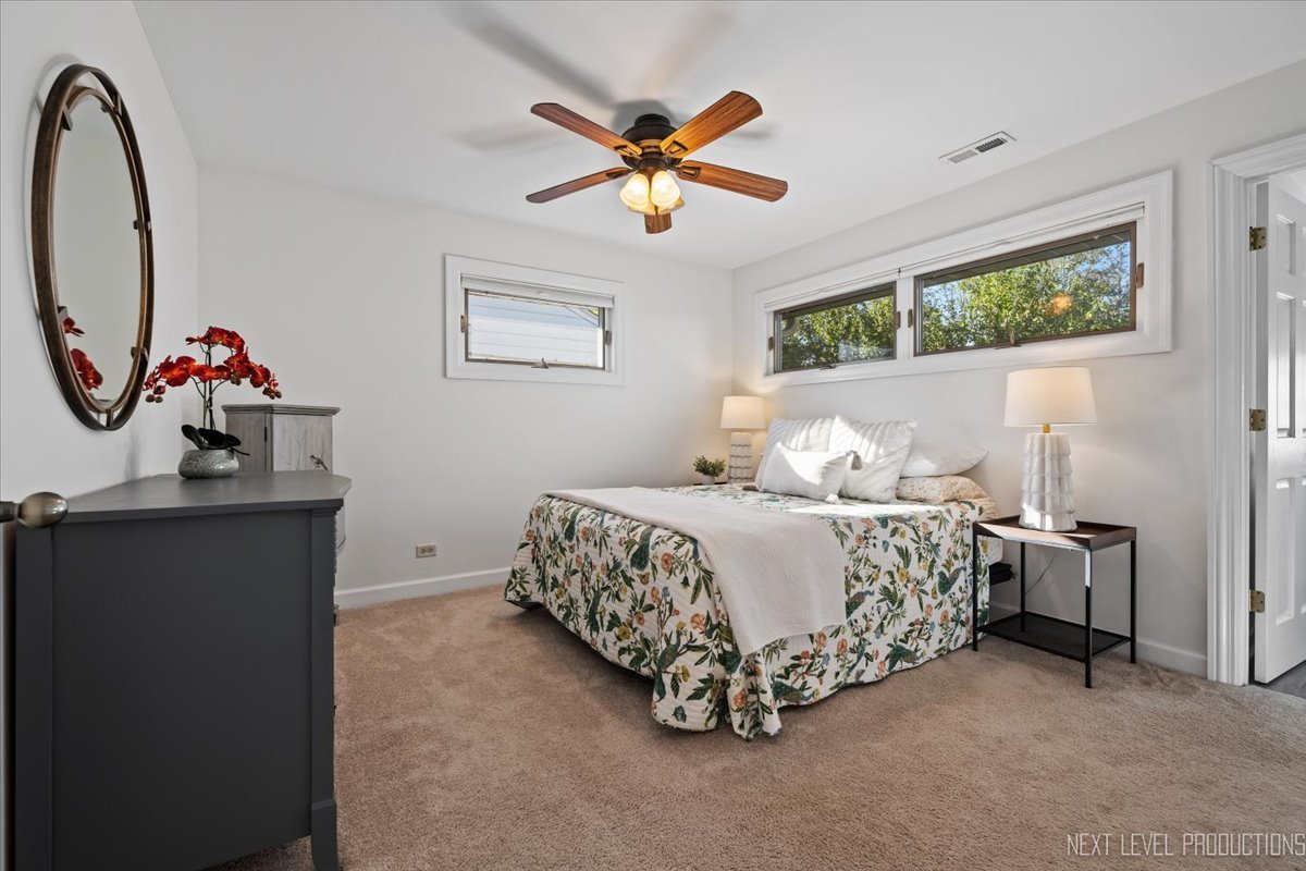 703 Wakeman Avenue Wheaton, IL 60187 - Photo 13 of 20 a bedroom with a bed and a chandelier