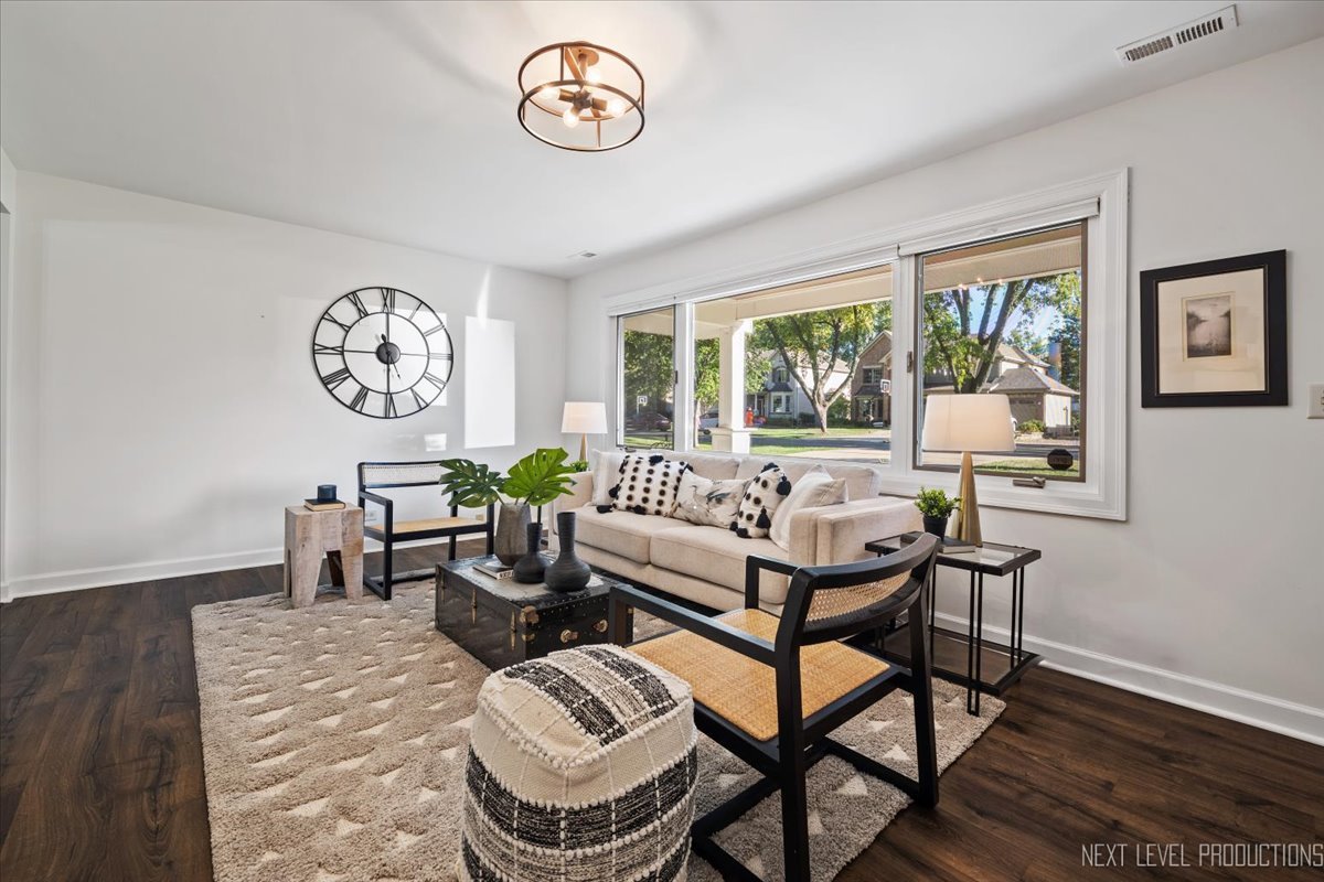 703 Wakeman Avenue Wheaton, IL 60187 - Photo 4 of 20 a view of a dining room with furniture a rug and wooden floor