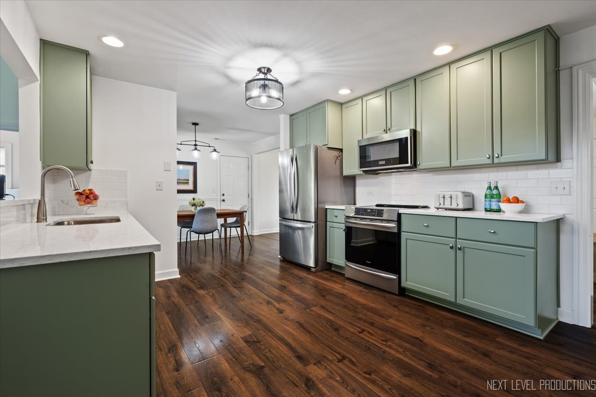 703 Wakeman Avenue Wheaton, IL 60187 - Photo 7 of 20 a kitchen with stainless steel appliances a microwave a stove a sink dishwasher a refrigerator and white cabinets with wooden floor