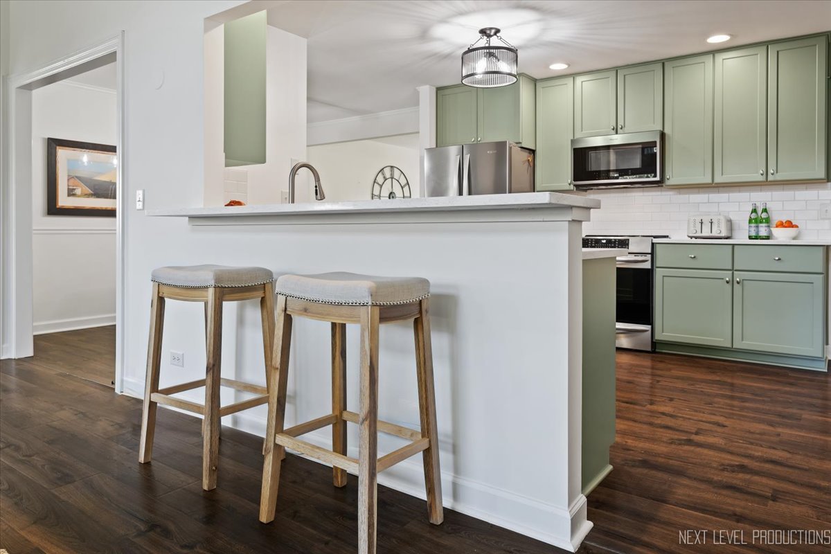 703 Wakeman Avenue Wheaton, IL 60187 - Photo 8 of 20 a kitchen with granite countertop a stove a sink and a microwave