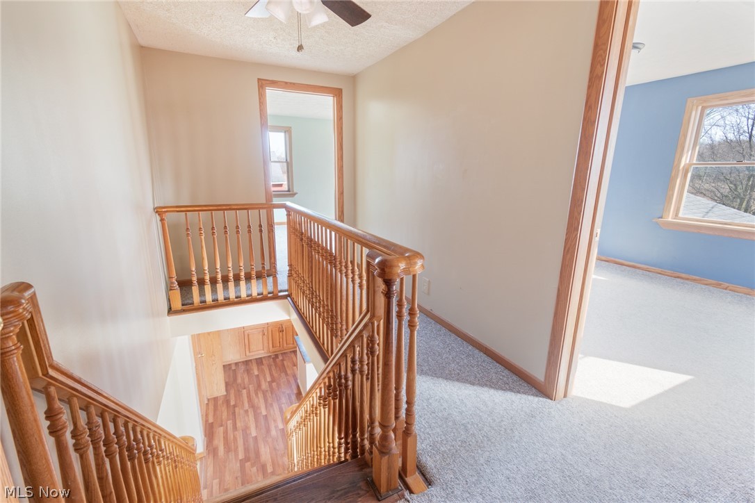16333 Courtney Road Alliance, OH 44601 - Photo 22 of 31 Stairway to second floor featuring light carpet, a textured ceiling, and ceiling fan
