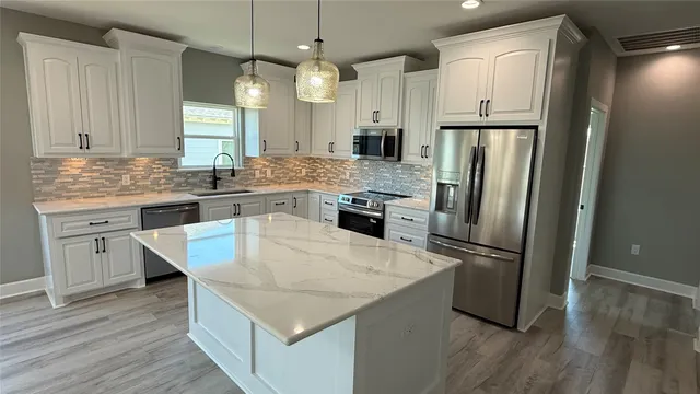 a kitchen with stainless steel appliances white cabinets and a refrigerator