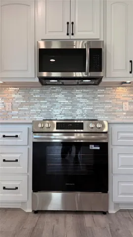 a kitchen with granite countertop a sink stove and cabinets
