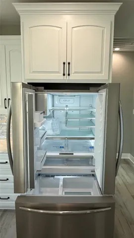 a large white kitchen with cabinets