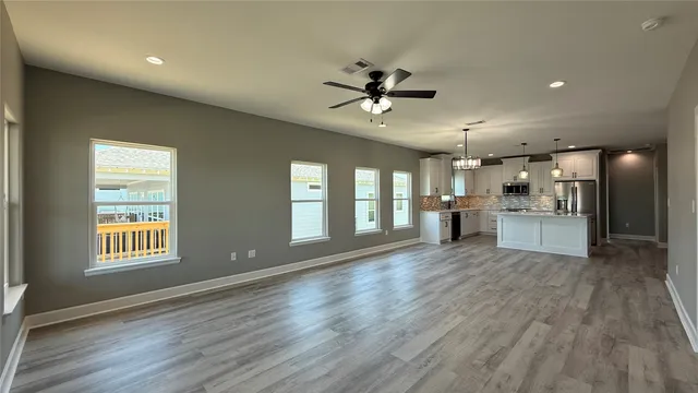 a kitchen with refrigerator cabinets and wooden floor