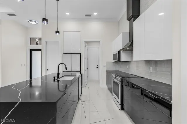 a kitchen with stainless steel appliances granite countertop a stove a sink and a refrigerator