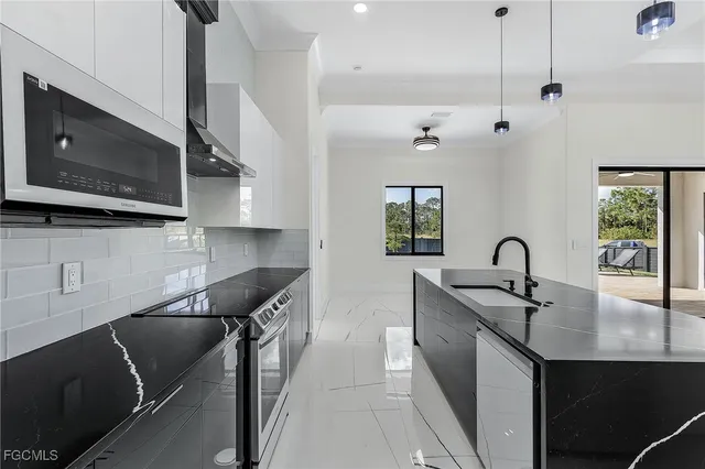 a kitchen with stainless steel appliances granite countertop a sink a stove and a microwave