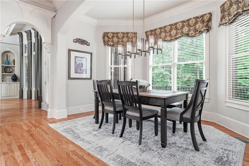8340 Colonial Place Duluth, GA 30097 - Photo 15 of 74 a view of a dining room with furniture wooden floor and chandelier