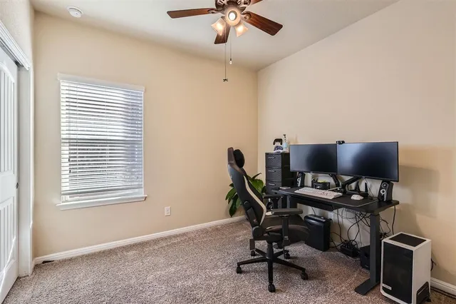 a view of a workspace with furniture and a window