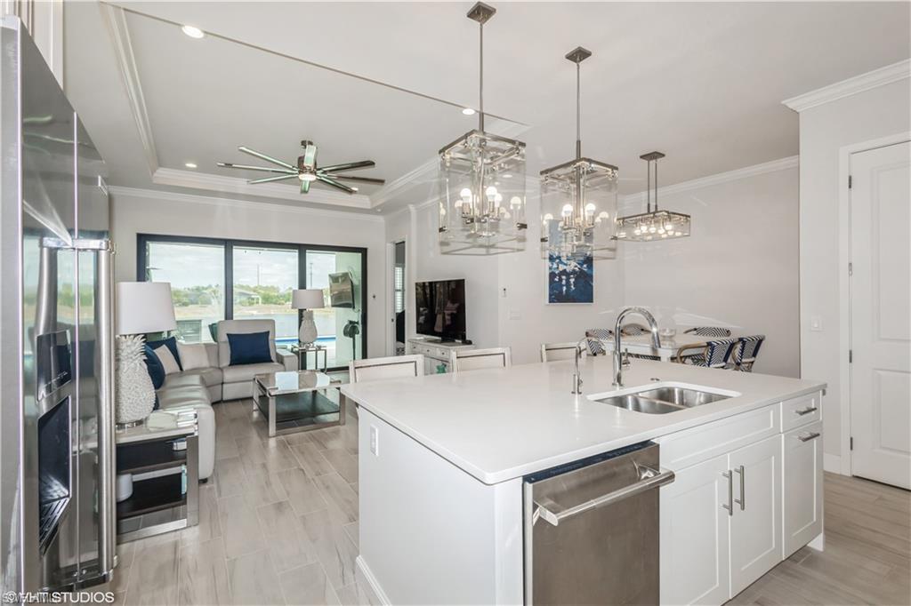14605 Kingfisher Loop Naples, FL 34120 - Photo 42 of 42 a view of a dining room and livingroom with furniture wooden floor a chandelier
