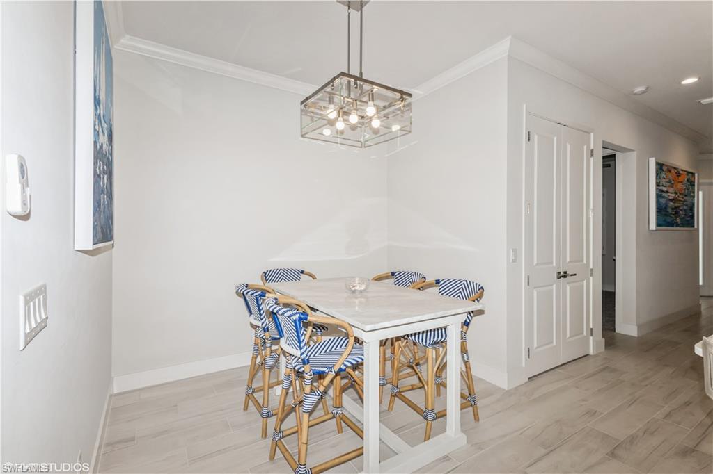14605 Kingfisher Loop Naples, FL 34120 - Photo 18 of 42 a view of a dining room with furniture and chandelier