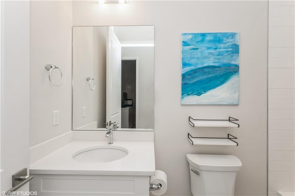 14605 Kingfisher Loop Naples, FL 34120 - Photo 26 of 42 a bathroom with a granite countertop sink toilet and mirror