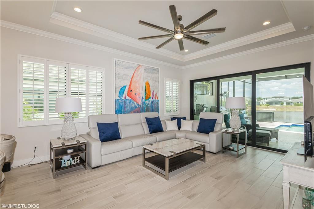 14605 Kingfisher Loop Naples, FL 34120 - Photo 6 of 42 a living room with furniture ceiling fan and a large window