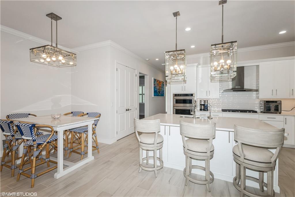 14605 Kingfisher Loop Naples, FL 34120 - Photo 9 of 42 a large kitchen with a table and chairs