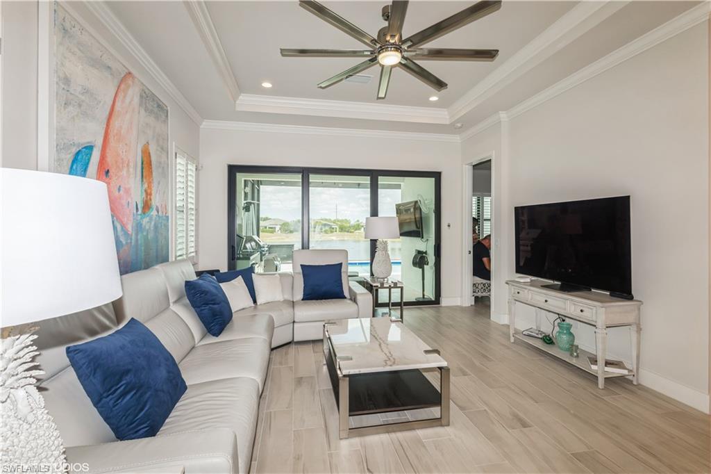 14605 Kingfisher Loop Naples, FL 34120 - Photo 10 of 42 a living room with furniture and a flat screen tv