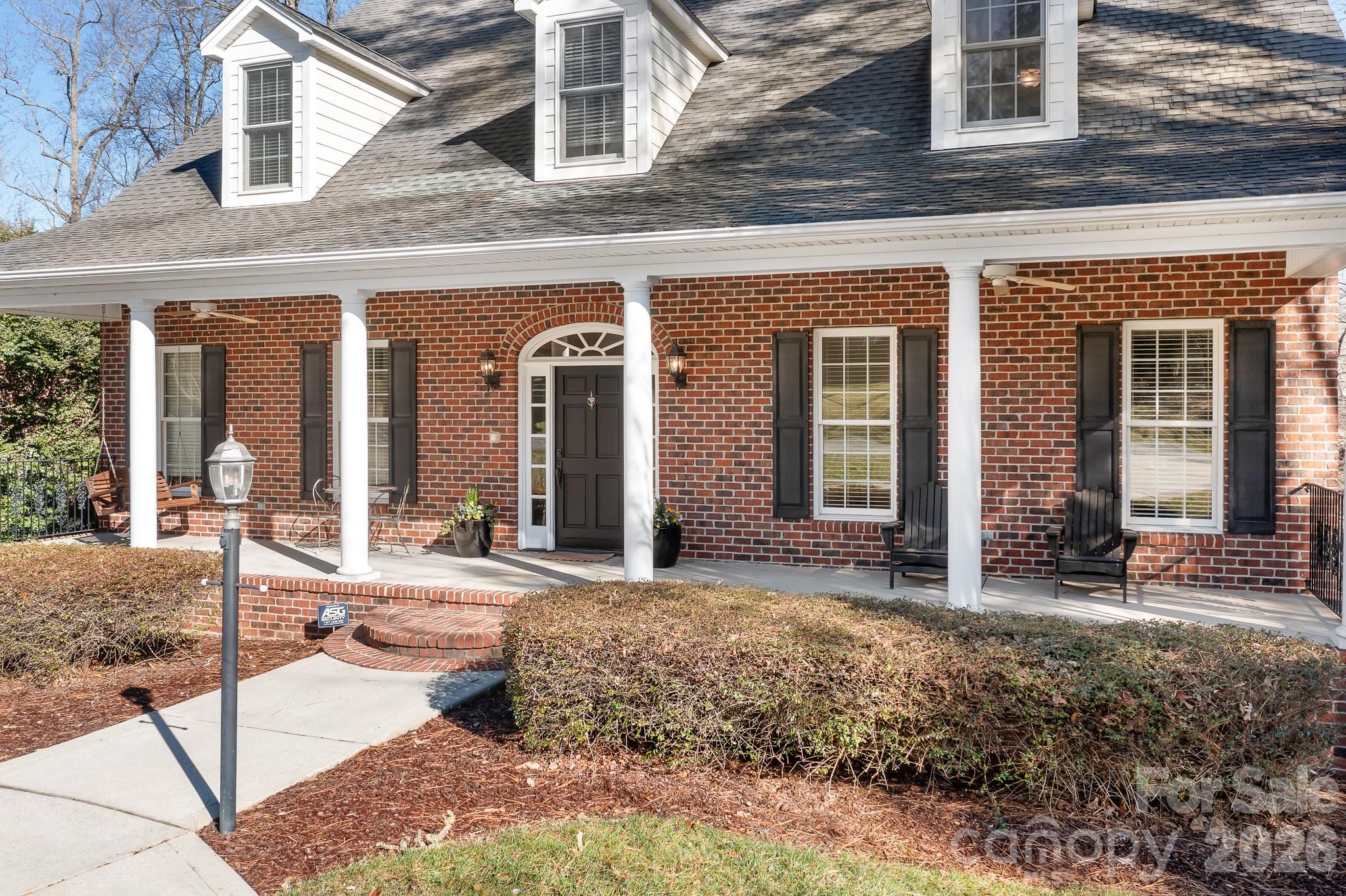 214 Lytham Lane Stanley, NC 28164 - Photo 2 of 46 a view of a brick house with large windows and plants