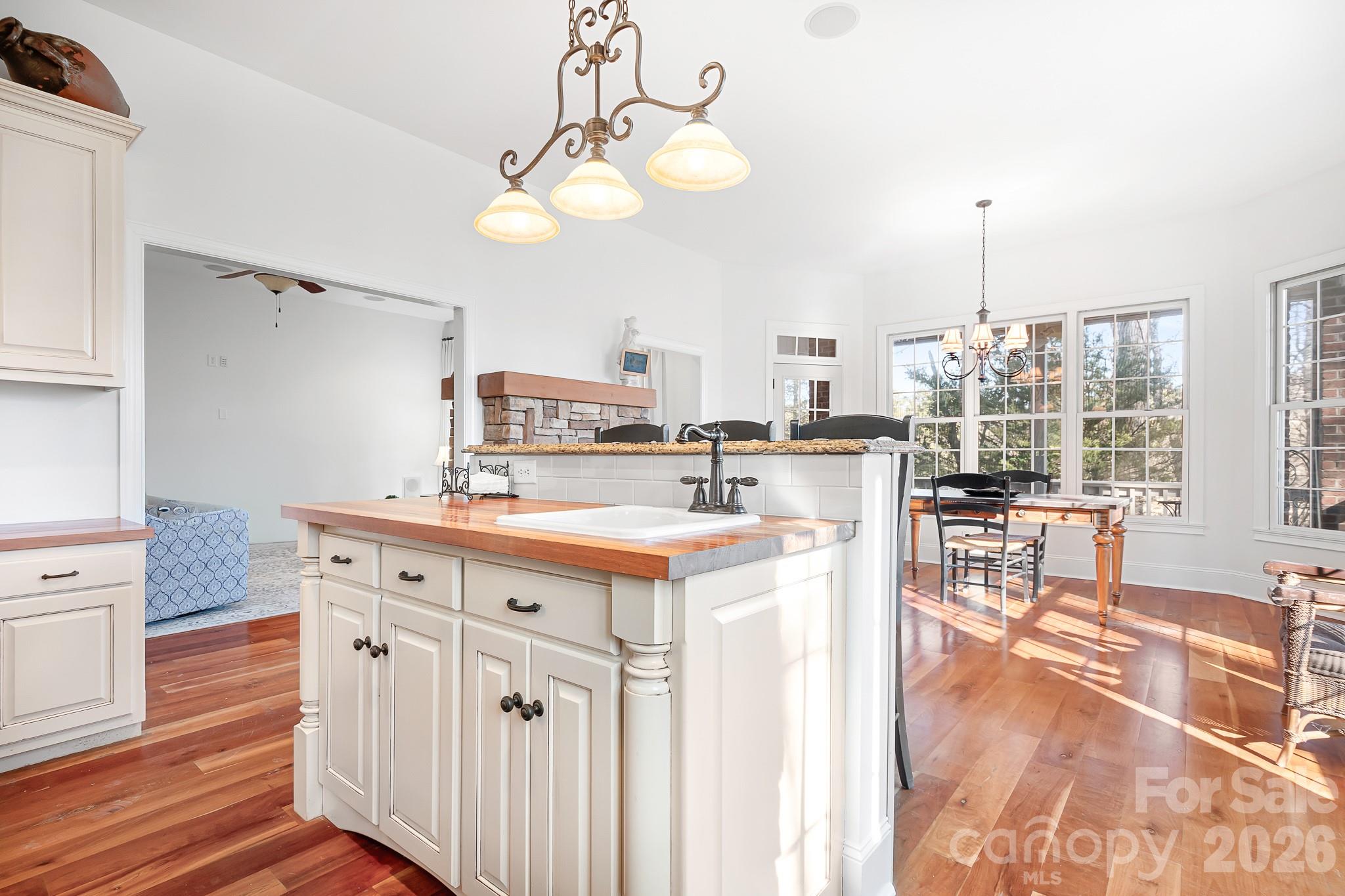 214 Lytham Lane Stanley, NC 28164 - Photo 7 of 46 a kitchen with kitchen island granite countertop a stove a sink a dining table and chairs with wooden floor