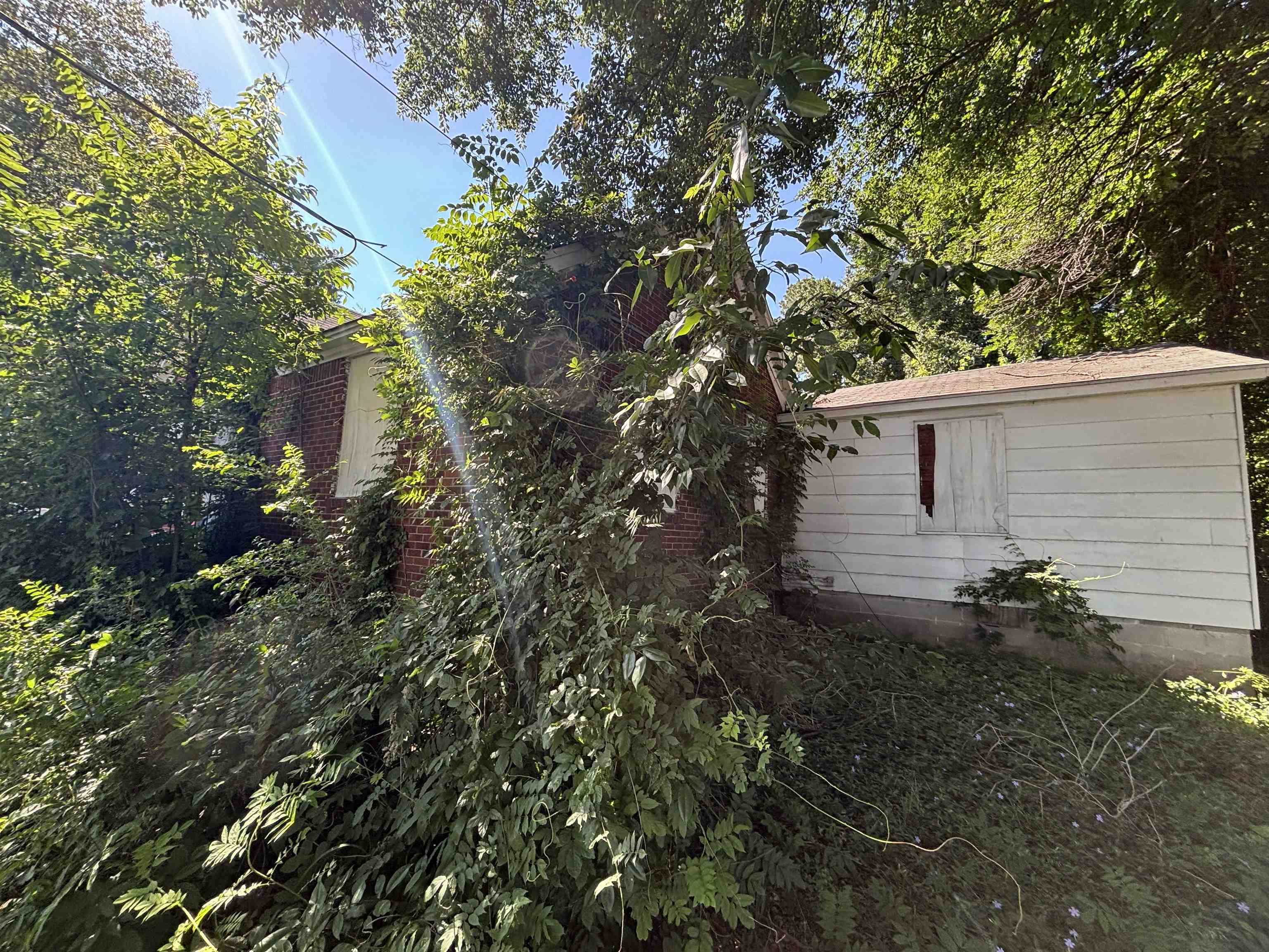 175 East Brooks Road Memphis, TN 38109 - Photo 4 of 7 Brick exterior with white trim details and a detached white-sided outbuilding