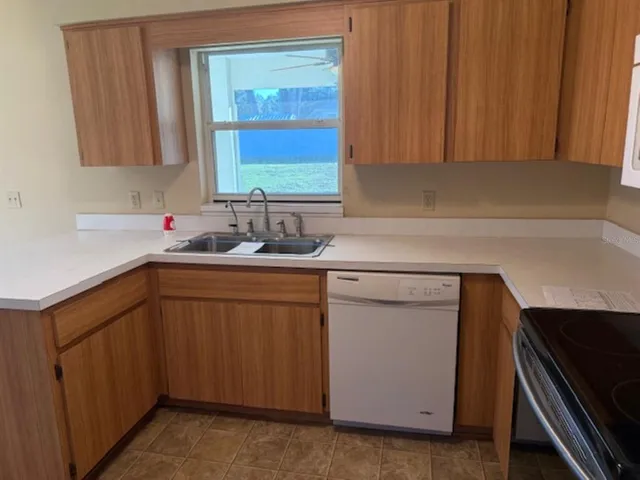 a kitchen with a sink cabinets and window