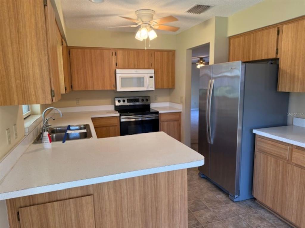 1335 East Silver Thorn Loop Hernando, FL 34442 - Photo 5 of 16 a kitchen with stainless steel appliances a refrigerator sink and microwave