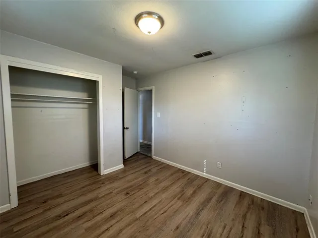 an empty room with wooden floor and closet