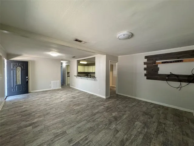 a view of empty room with kitchen