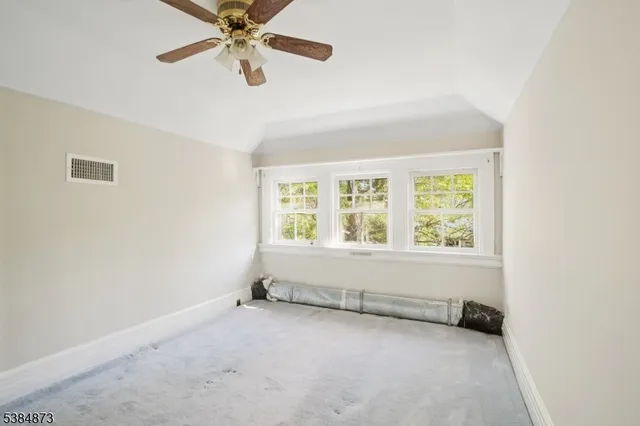 an empty room with chandelier fan