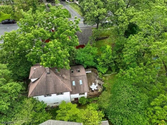 an aerial view of a house with yard outdoor seating and trees