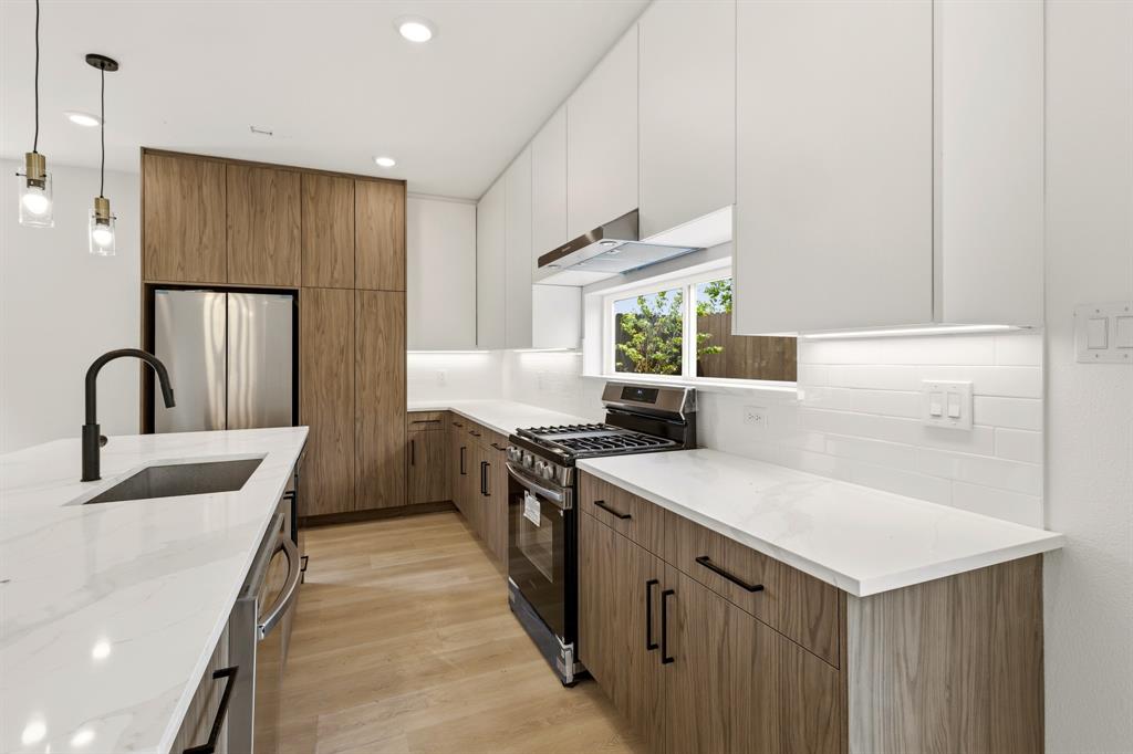 415 North Patton Avenue Dallas, TX 75203 - Photo 8 of 20 The kitchen features a contemporary design with white upper cabinets and wood-grain lower cabinetry, complemented by white countertops