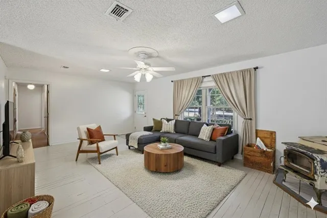 a living room with furniture a flat screen tv and a large window