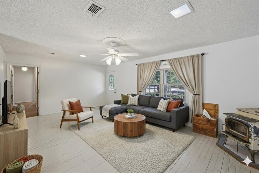 a living room with furniture a flat screen tv and a large window